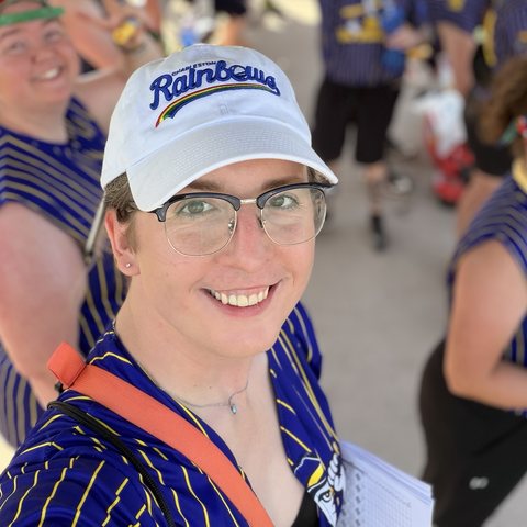 Jayde Cork, smiling in a Charleston Rainbows cap at a softball game